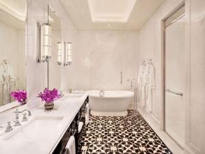 a white bathroom with a tub and a sink at Raffles Singapore in Singapore