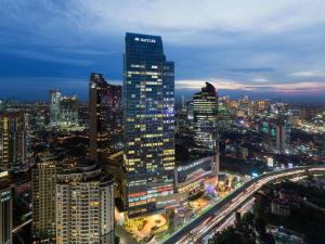 una vista notturna di una grande città con edifici di Raffles Jakarta a Giacarta