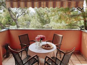 a table with chairs and flowers on a balcony at Apartments Paklenica in Starigrad-Paklenica