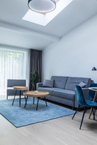 uma sala de estar com um sofá e uma mesa em Apartment Hotel Laisve em Druskininkai