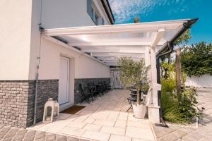 una pérgola blanca al lado de un edificio en Pumpion, en Valtice