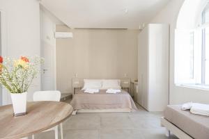 a white bedroom with a bed and a table at Lux Caracciolo in Naples