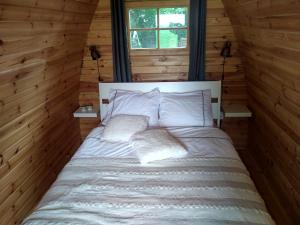 a bed in a log cabin with two pillows at Weids Zicht BB Weidszicht in Doezum +8 photos
