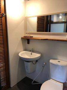 a bathroom with a toilet and a sink and a mirror at Anattaya Holiday Home in Ko Yao Noi