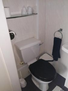 uma pequena casa de banho com um WC com uma tampa preta em The Garnett em Blackpool