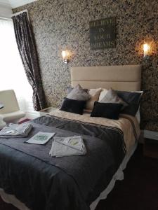 Un dormitorio con una cama grande con algo de ropa. en The Garnett en Blackpool