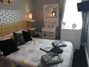 um quarto com uma cama com roupas em The Garnett em Blackpool