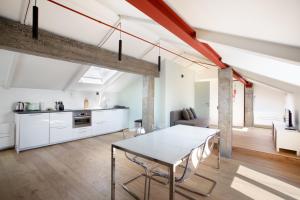 cocina y sala de estar con mesa y sillas en Mato Apartment Torino en Turín