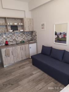 a living room with a couch and a kitchen at Ethra luxury studios in Asprovalta