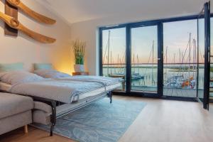 Schlafzimmer mit einem Bett und Blick auf den Yachthafen in der Unterkunft Yachtenkieker in Heiligenhafen