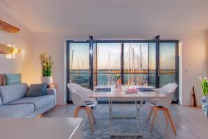 ein Wohnzimmer mit einem Tisch und Hafenblick in der Unterkunft Yachtenkieker in Heiligenhafen