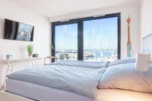 Schlafzimmer mit einem Bett und Hafenblick in der Unterkunft Yachtenkieker in Heiligenhafen