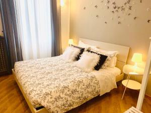 1 dormitorio con 1 cama con sábanas y almohadas blancas en B&B Mela, en Verona