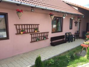 une maison rose avec une terrasse et une table dans l'établissement Casa rustica cu terasa, à Mediaş
