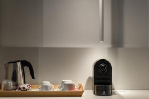 a kitchen counter with a coffee maker and coffee cups at Lux Caracciolo in Naples