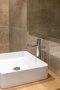 a white sink in a bathroom next to a wall at Lux Caracciolo in Naples