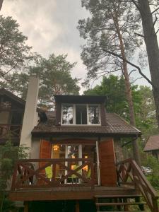 Casa pequeña con porche y ventana en Domek wypoczynkowy w lesie nad jeziorem, en Ocypel