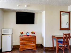 Habitación con mesa y TV en la pared. en OYO Hotel Killeen East Central en Killeen