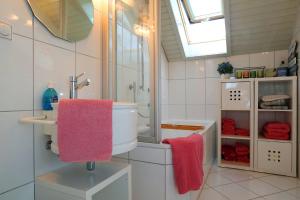 een badkamer met een wastafel en een douche met roze handdoeken bij Auszeit Schluchsee - Fewo Tanja - Oase der Stille - in Schluchsee
