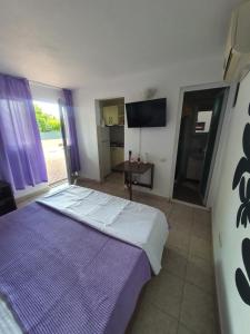 a bedroom with a large bed with a purple blanket at Casa Maria Saturn in Saturn