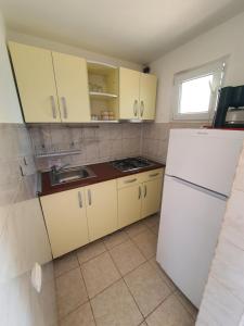 a kitchen with yellow cabinets and a white refrigerator at Casa Maria Saturn in Saturn