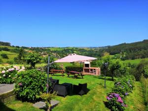 a garden with a picnic table and an umbrella at Apartamentos Corona in Comillas