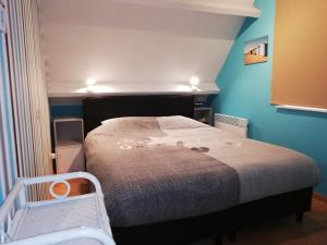 デ・パンネにあるAppartement De Panne Zonneblikの青い壁のベッドルーム1室(ベッド1台付)