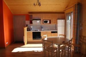a kitchen with a table and a table and chairs at Chalets de Trémontagne 3 étoiles in Prénovel