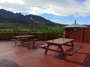 twee picknicktafels op een terras met een tuinhuisje bij Engimyri Lodge in Akureyri