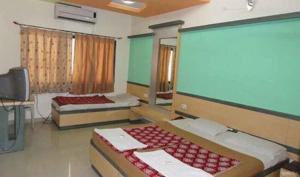 a room with two beds and a large screen at Hotel Shail Shikhar in Joshīmath