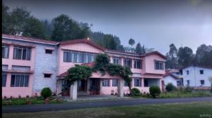 a pink building with trees on the side of it at Hotel Shail Shikhar in Joshīmath