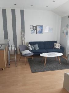 uma sala de estar com um sofá azul e uma mesa em Adriatic em Mali Lošinj