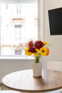 a vase of flowers sitting on a table at Lux Caracciolo in Naples