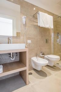 a bathroom with a sink and a toilet and a mirror at Lux Caracciolo in Naples