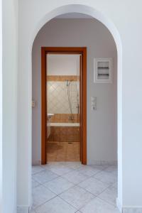 ein Flur mit einer Tür zu einem Badezimmer mit Badewanne in der Unterkunft Lagadi Apartment 3 in Lassi + 16 Fotos