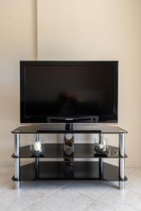 Ein Flachbildfernseher steht auf einem Tisch. in der Unterkunft Lagadi Apartment 3 in Lassi
