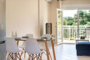 ein Esszimmer mit einem Tisch und weißen Stühlen in der Unterkunft Lagadi Apartment 3 in Lassi