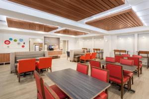 uma sala de jantar com mesas e cadeiras vermelhas em Holiday Inn Express & Suites Tilton, an IHG Hotel em Tilton