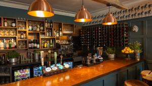 a bar with a counter with bottles of alcohol at The Bear Hotel in Wareham