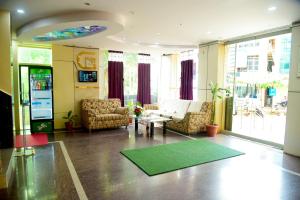 a living room with two chairs and a green rug at Grand Plaza in Dhārwād +27 photos
