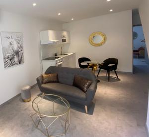 a living room with a couch and a table at Le Nid du Faubourg in Beaune
