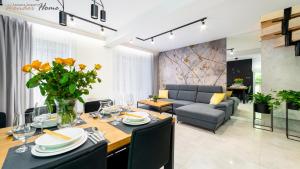 a dining room and living room with a table and chairs at Wonder Home - Domki górskie wolnostojące z prywatnymi tarasami - zielona okolica in Karpacz