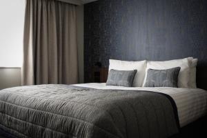 a bed with a white comforter and pillows at The Comet London Hatfield in Hatfield