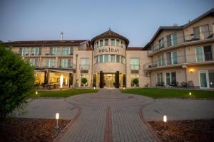 a building with a brick walkway in front of it at Sunshine 208 apartman in Balatonszárszó