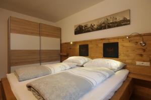 2 łóżka pojedyncze w pokoju z drewnianymi ścianami w obiekcie Tiroler Ferienwohnungen Haus Petra w mieście Kirchdorf in Tirol