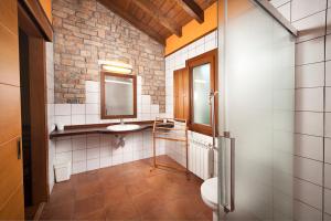 a bathroom with a sink and a toilet and a mirror at Apartamentos La Calvera in Parres de Llanes