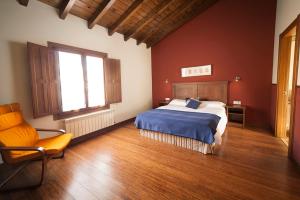 1 dormitorio con 1 cama y 1 silla en Apartamentos La Calvera, en Llames de Parres