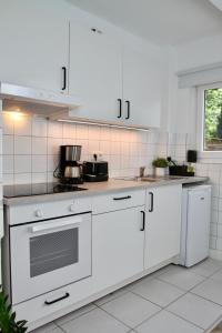 een keuken met witte kasten en een fornuis met oven bij Apartmenthaus in der Metzstraße in Bochum