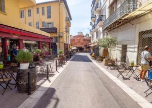 une rue vide dans une ville avec des tables et des chaises dans l'établissement Grand appartement 4 pièces centre de Cannes, à Cannes