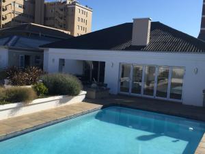 - une piscine en face d'une maison dans l'établissement The Blue Lotus Guest House, à Port Elizabeth